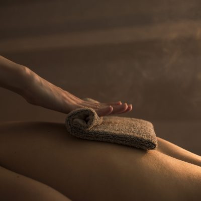 therapist-massaging-woman-s-back-with-hot-towel-spa